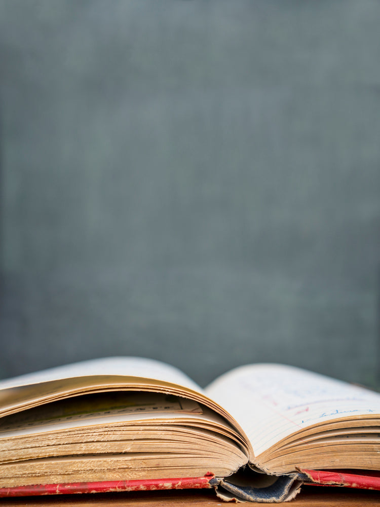 Old Book open in front of Blackboard