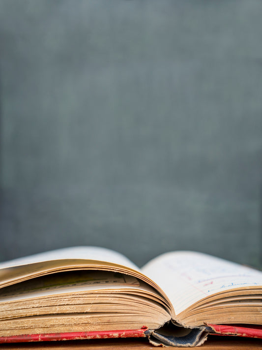 Old Book open in front of Blackboard